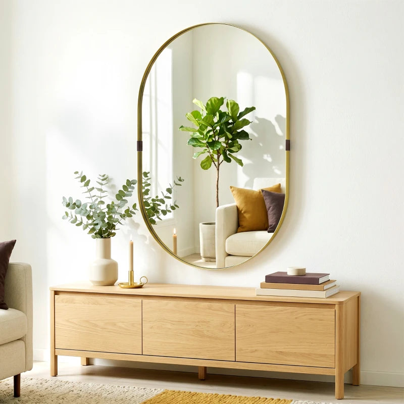 Gold-tone oval wall mirror with slim elevated frame and clear reflective surface