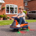 Orange kids electric wiggle car with RGB underglow, child riding outdoors