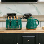 Green toaster and kettle on a wooden surface with black accents and cord base.