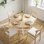 Folding drop-leaf dining table with light wood round top and matching wooden chairs