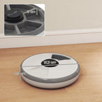 Grey automatic cat feeder on floor with top button and side dimensions