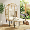 Beige rattan egg chair with white cushion and matching footstool, draped throw