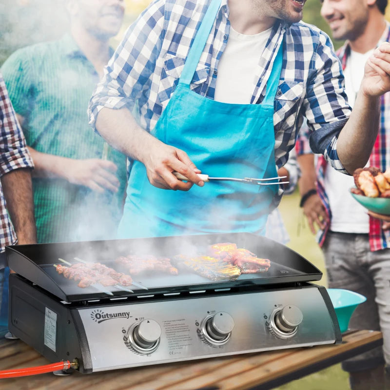 Portable tabletop gas griddle grill with three burner controls and black cooking surface
