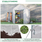 Walk-in greenhouse with green frame holding potted plants on two-tier shelf, clear mesh cover
