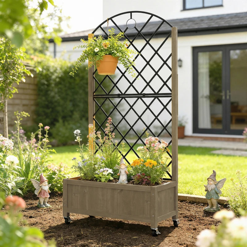 Tall raised planter with black metal trellis and flowers in a wooden bed