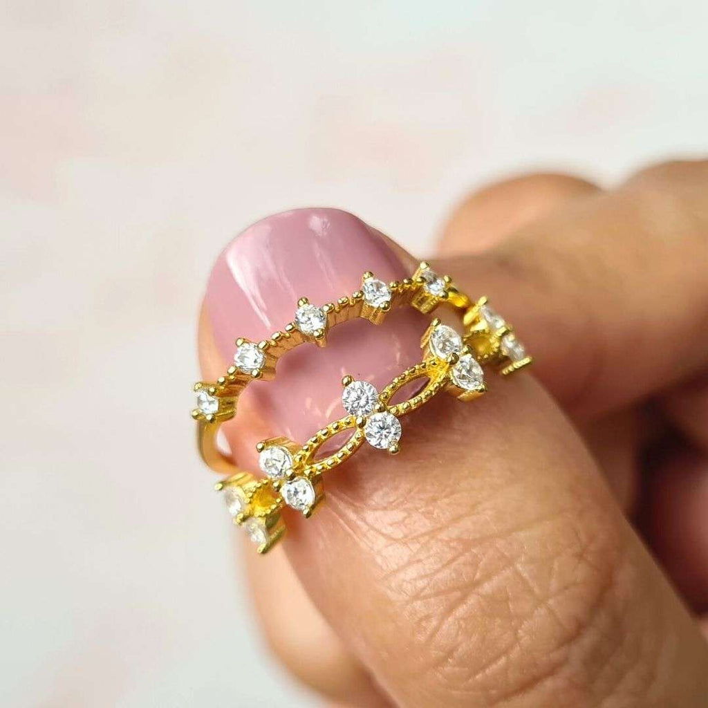 Gold crystal ring close-up with marquise stones and a round center on curved band