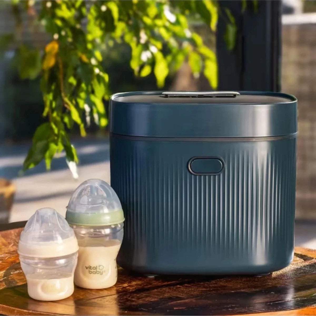 Smoky blue baby UV steriliser on table with baby bottles beside it