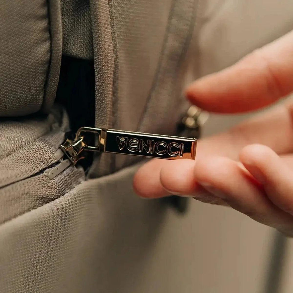 Venicci logo metal buckle on stroller strap, close-up