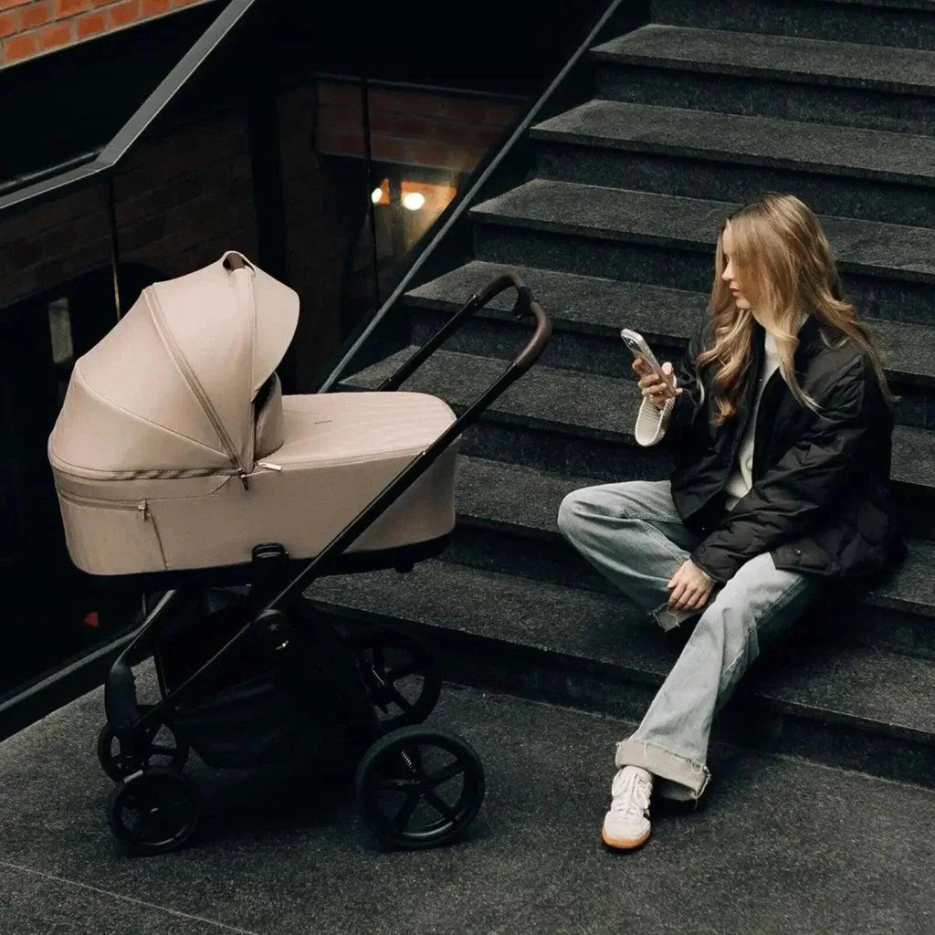 3-in-1 stroller with light seat and black frame, front wheels visible