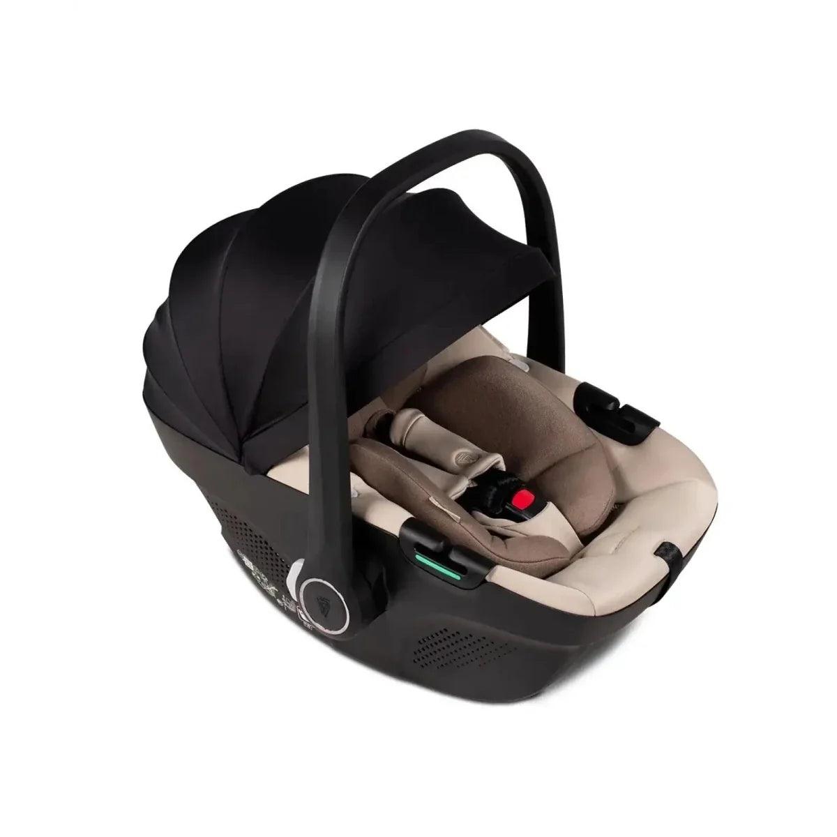 Beige infant car seat with black base and handle, side view