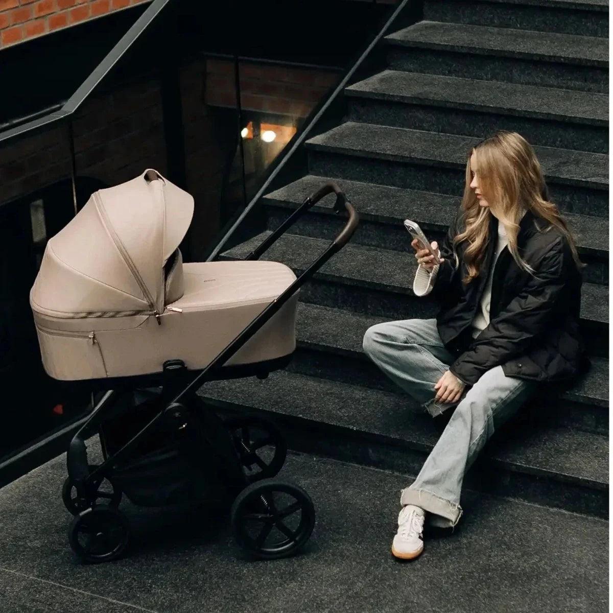 Beige pushchair seat on dark stroller frame with large wheels