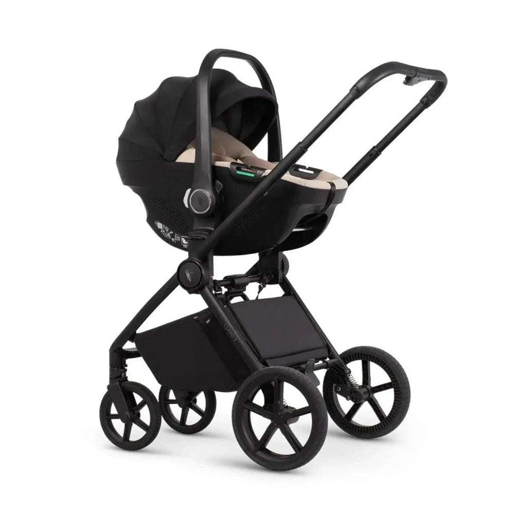 Black stroller with beige-lined carrycot and black wheels