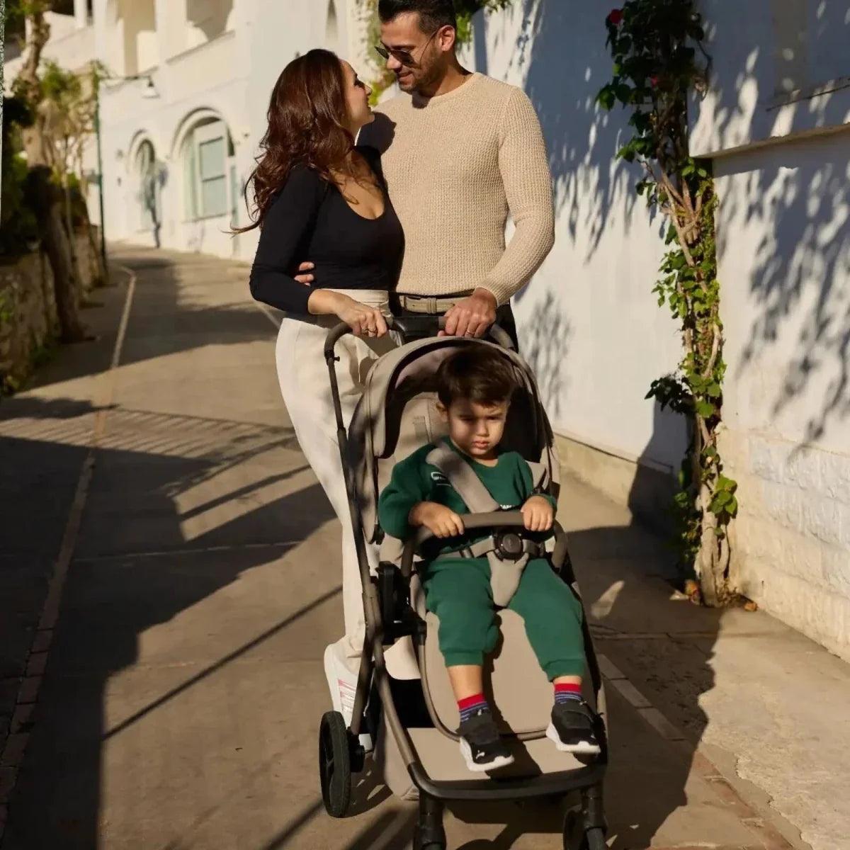 Latte stroller with toddler seat, beige fabrics and black wheels, outdoors