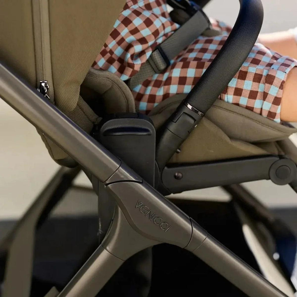 Beige stroller with padded seat and blue check-pattern insert, black handle