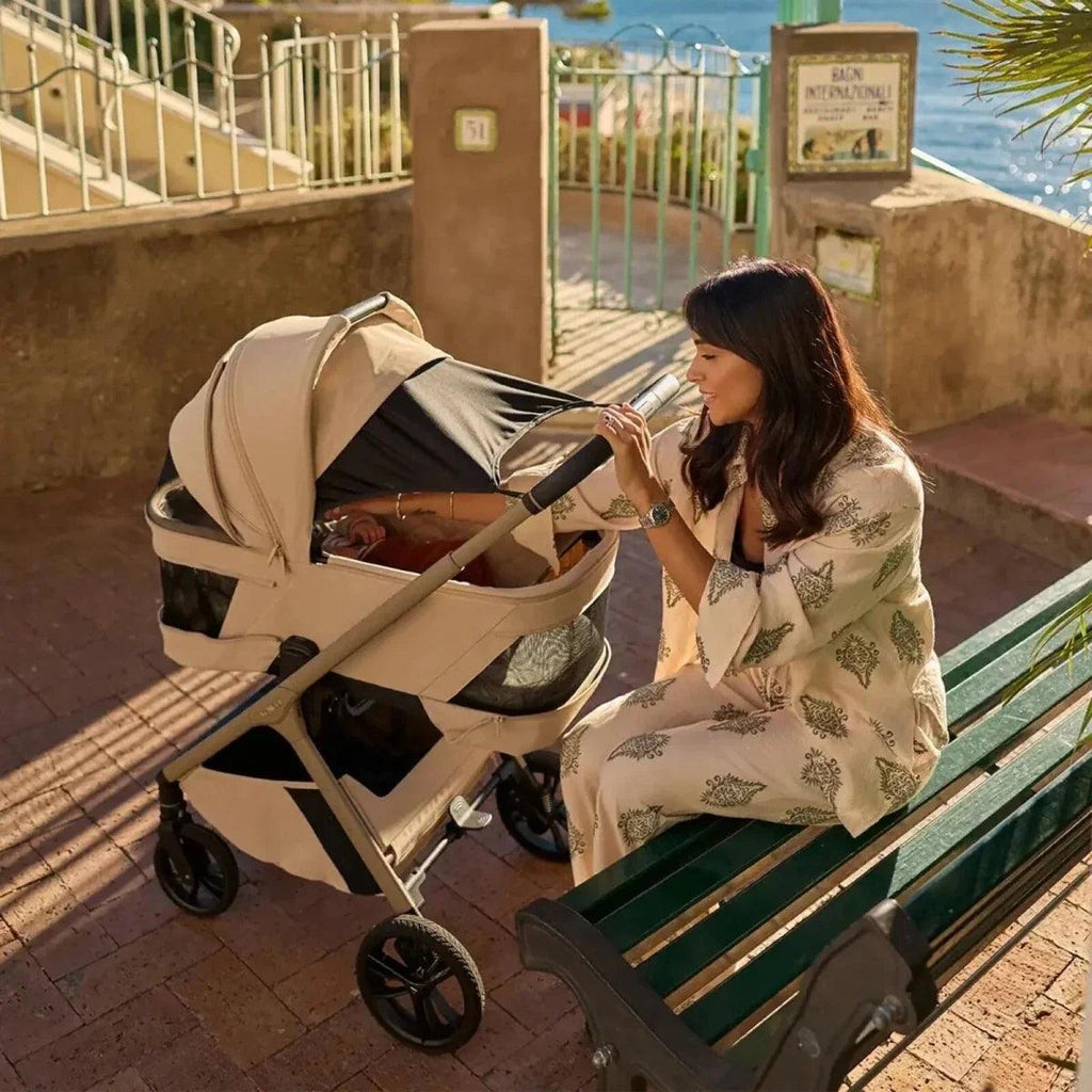 Beige 3-in-1 stroller with carrycot and open hood, side angle