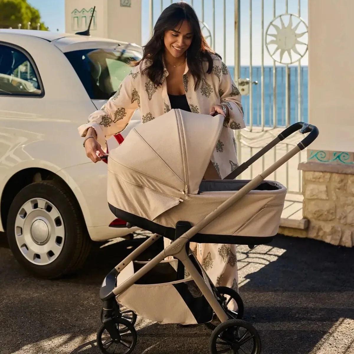 Beige stroller with seat and canopy, wheeled frame