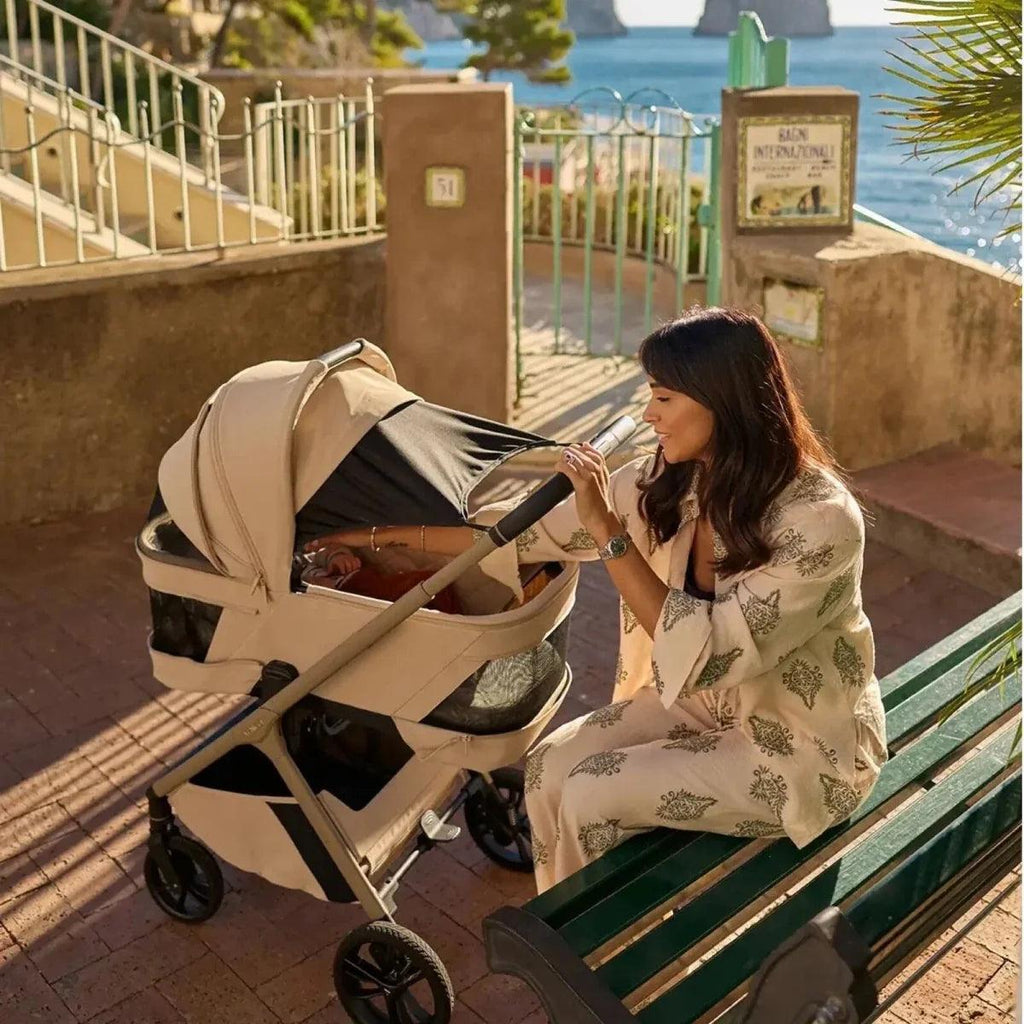 Beige stroller with open seat and canopy, side view