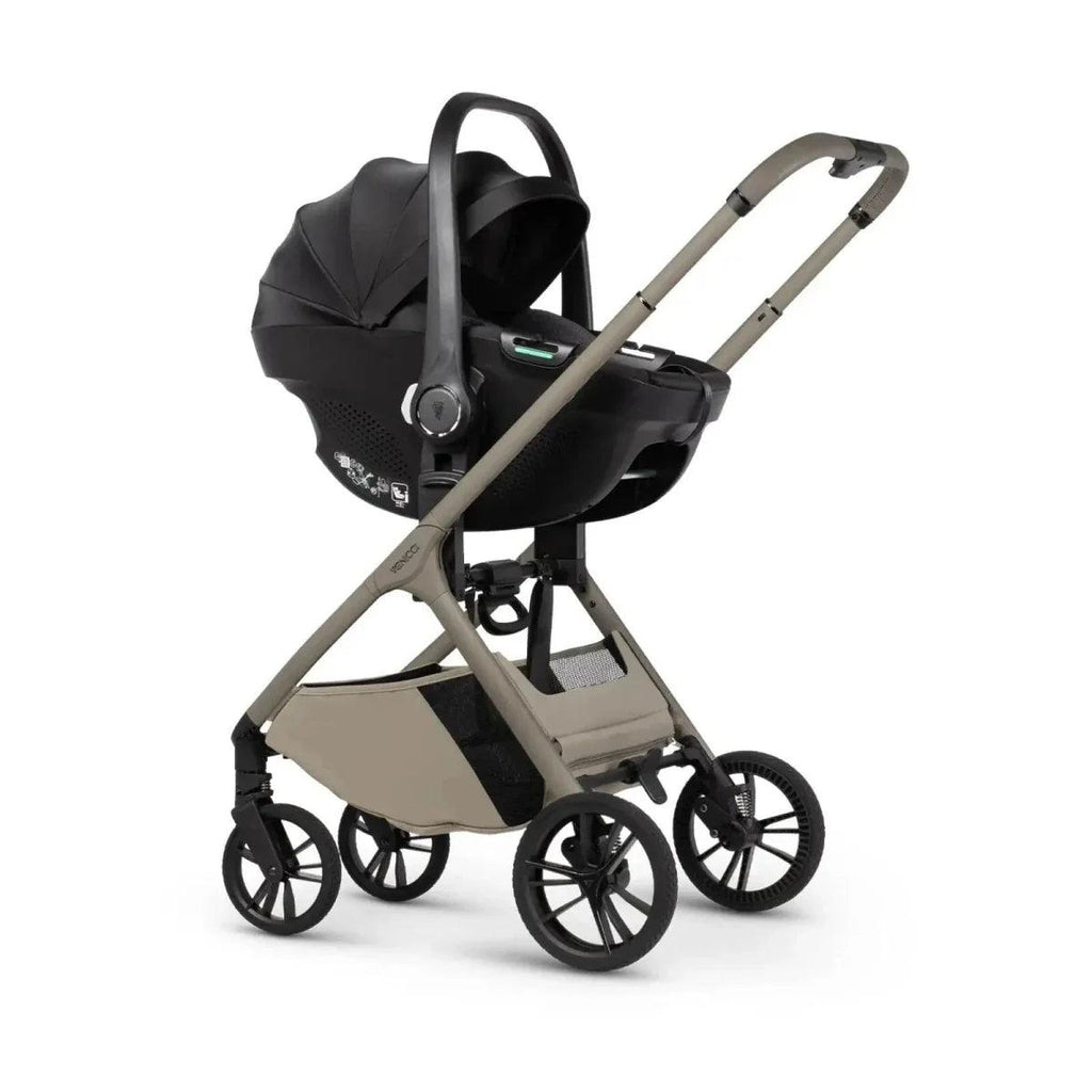 Black infant car seat on latte stroller frame, three-quarter view