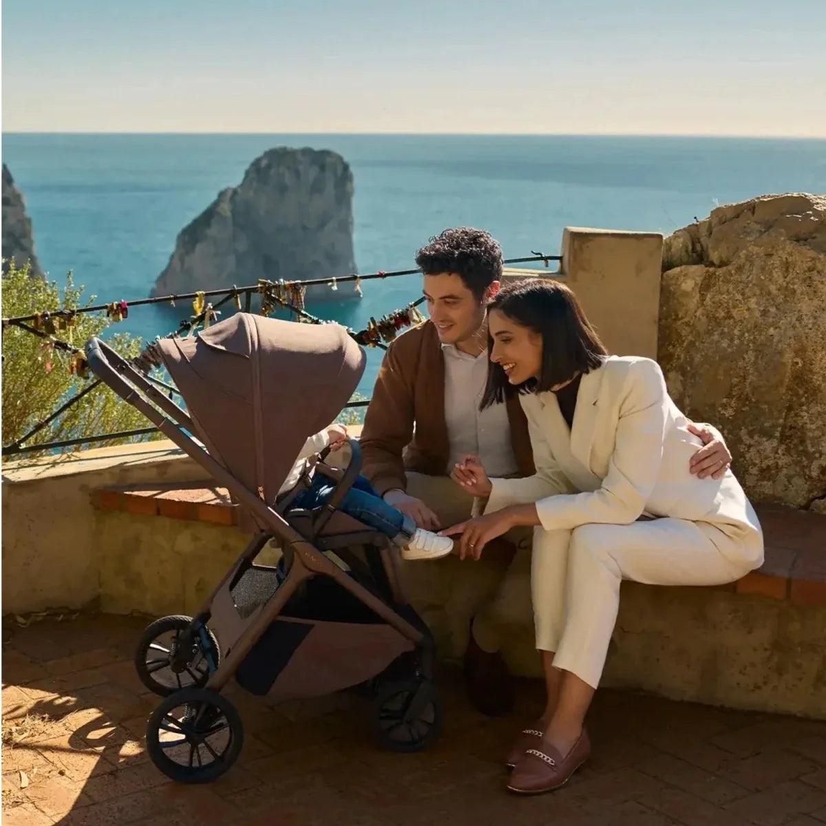 Dark stroller with canopy and carrycot base, parked on patio