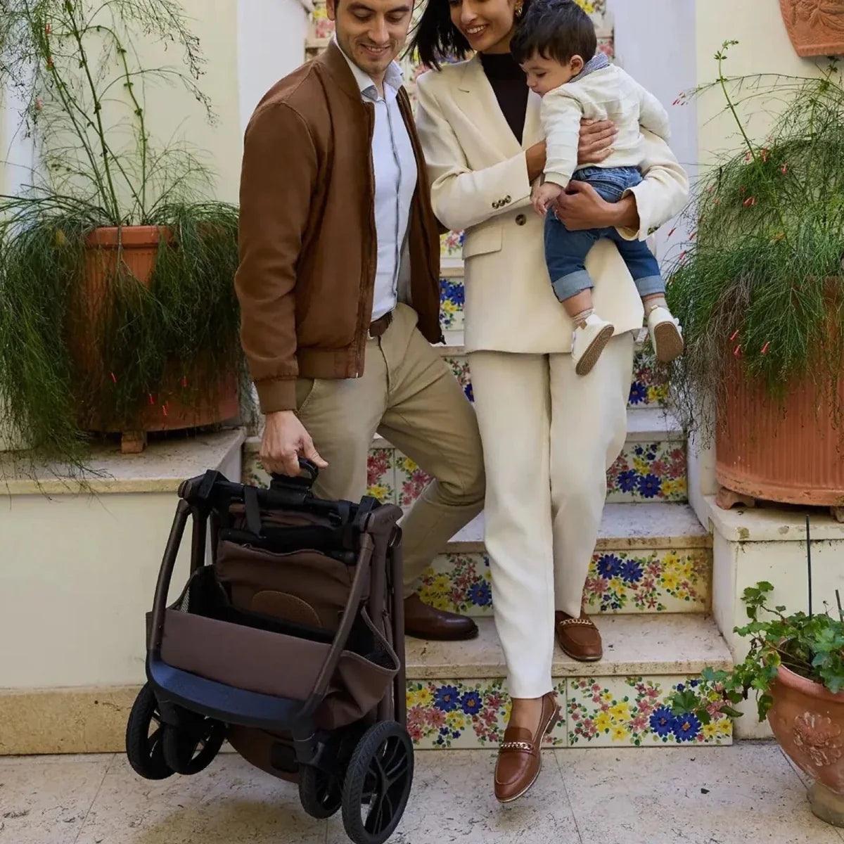 Compact stroller with carrycot and canopy, standing on tiled steps