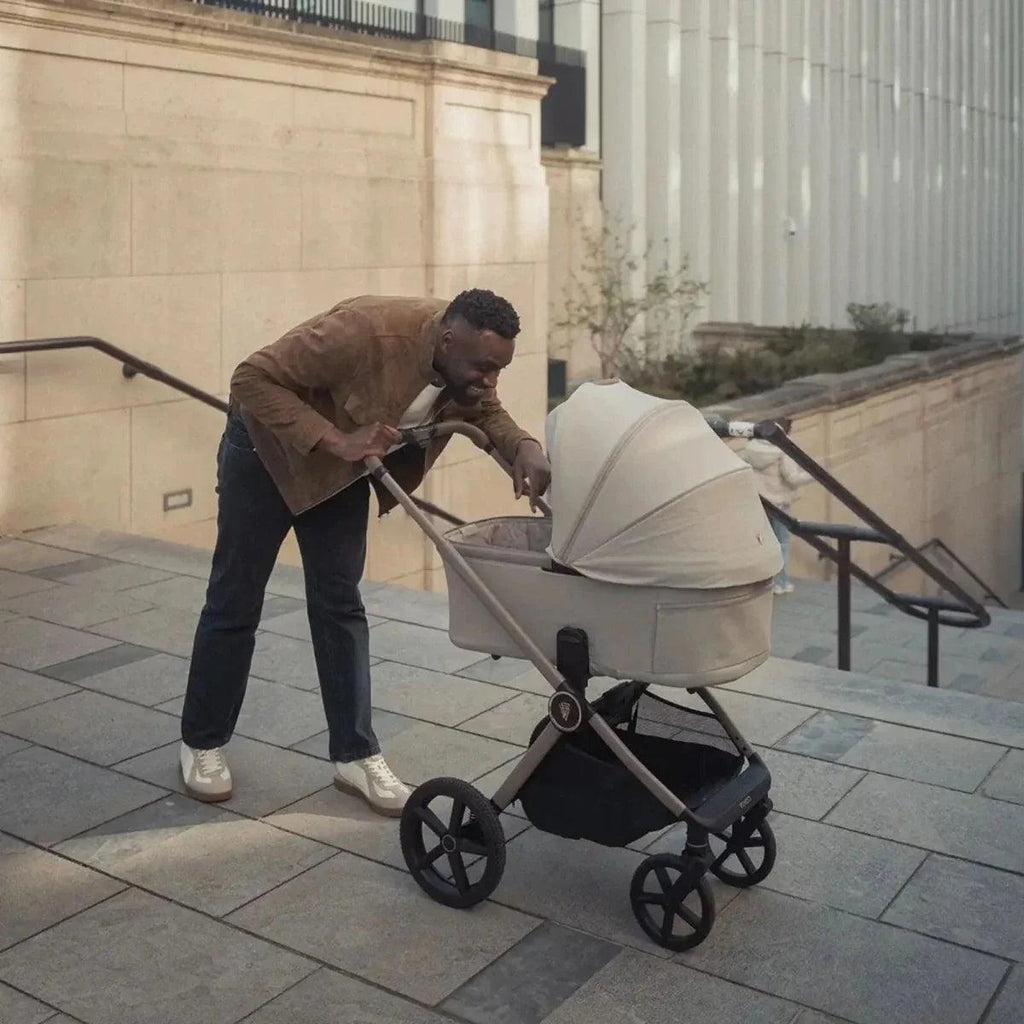 Pebble stroller with canopy hood and front wheels, near steps