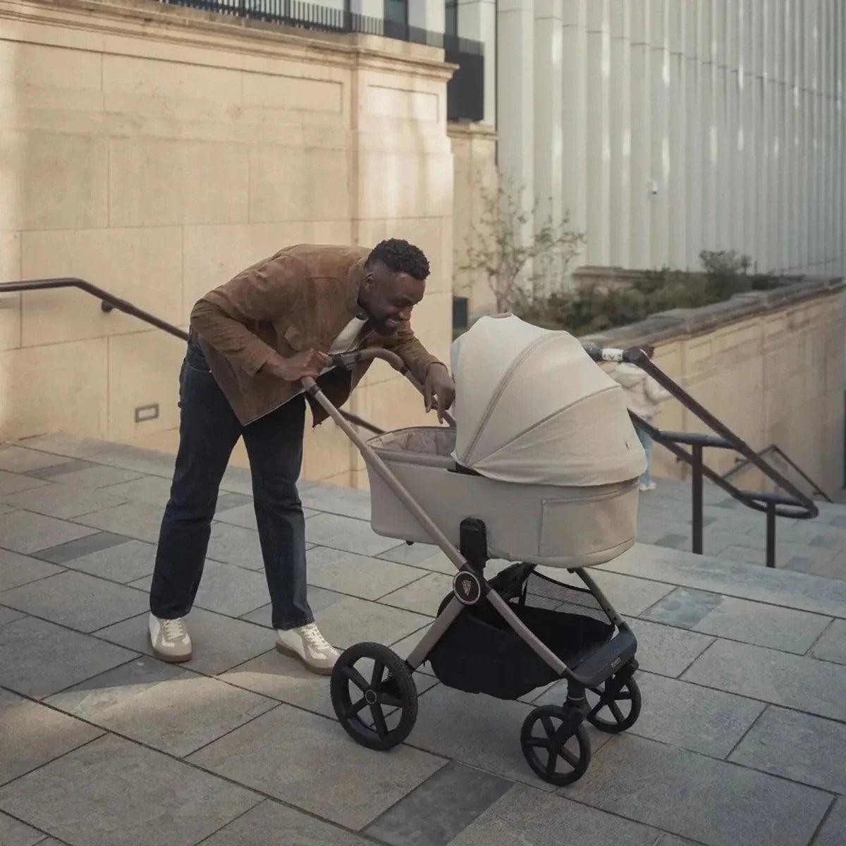 Pebble stroller with canopy hood and front wheels, near steps