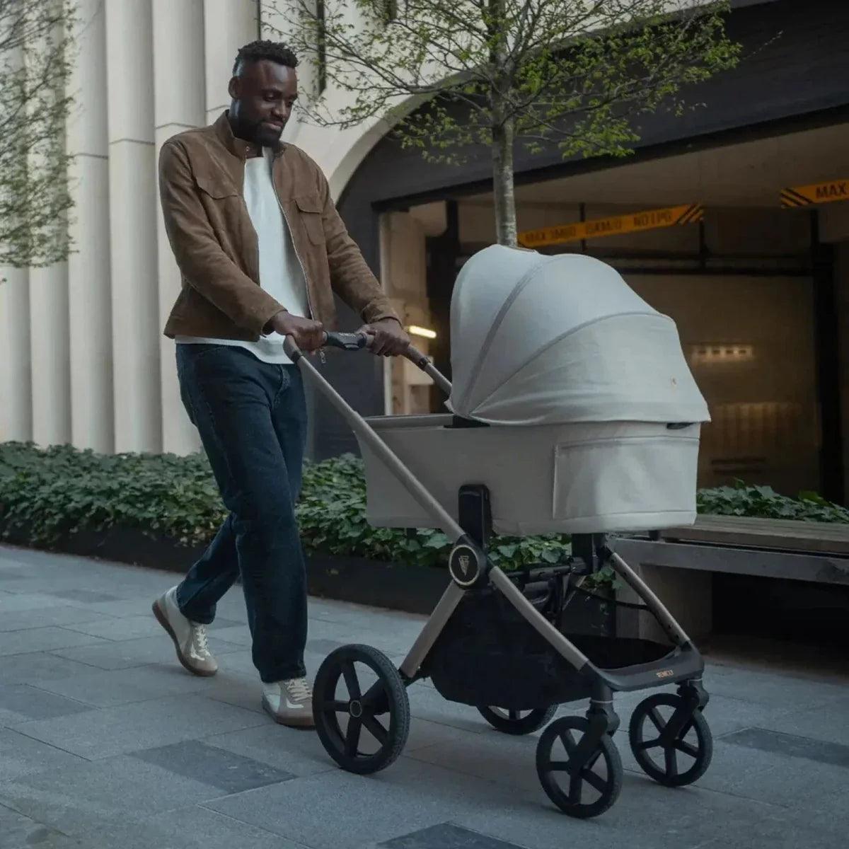 Baby stroller with light carrycot, extendable canopy, and four-wheel frame