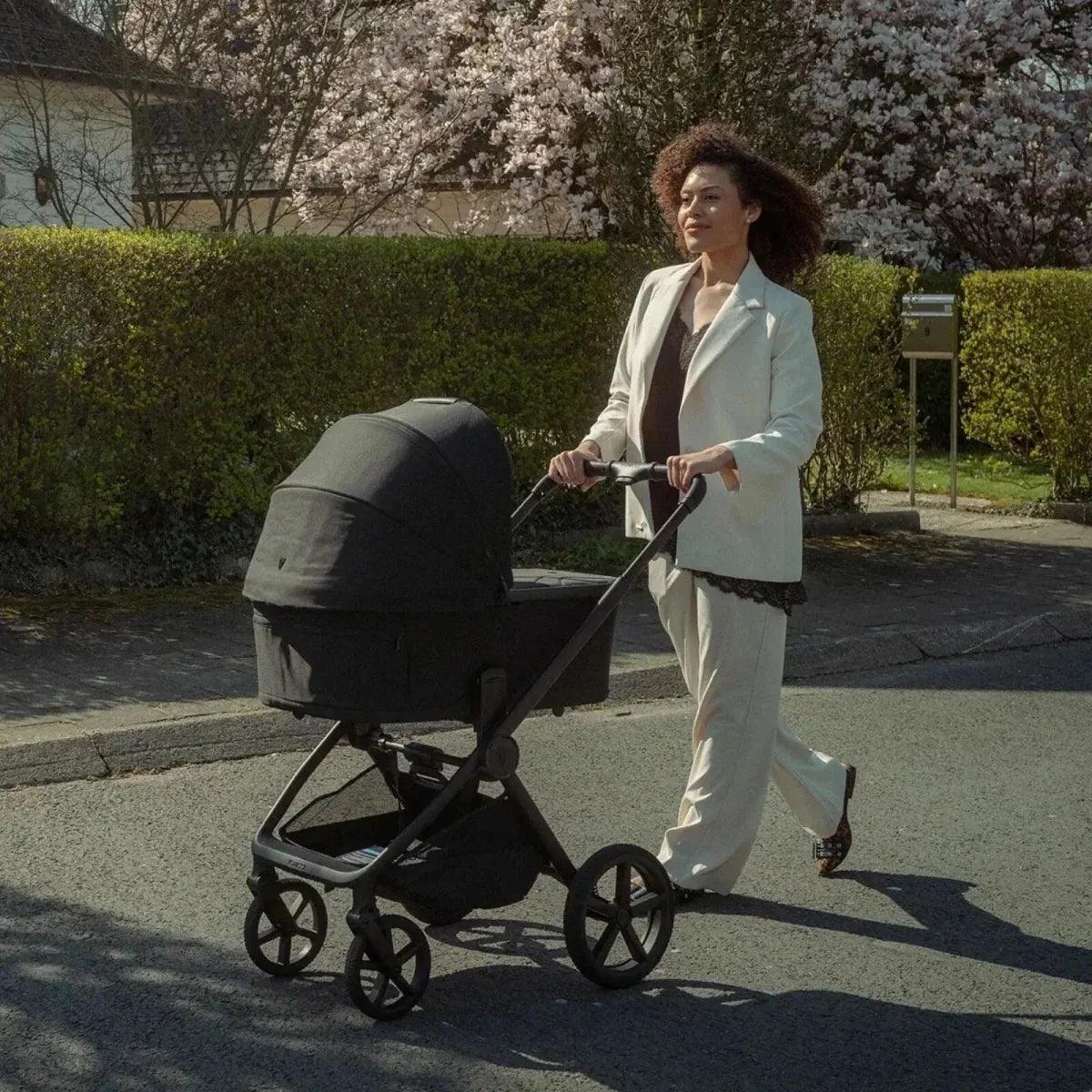 Black stroller with attached beige infant car seat