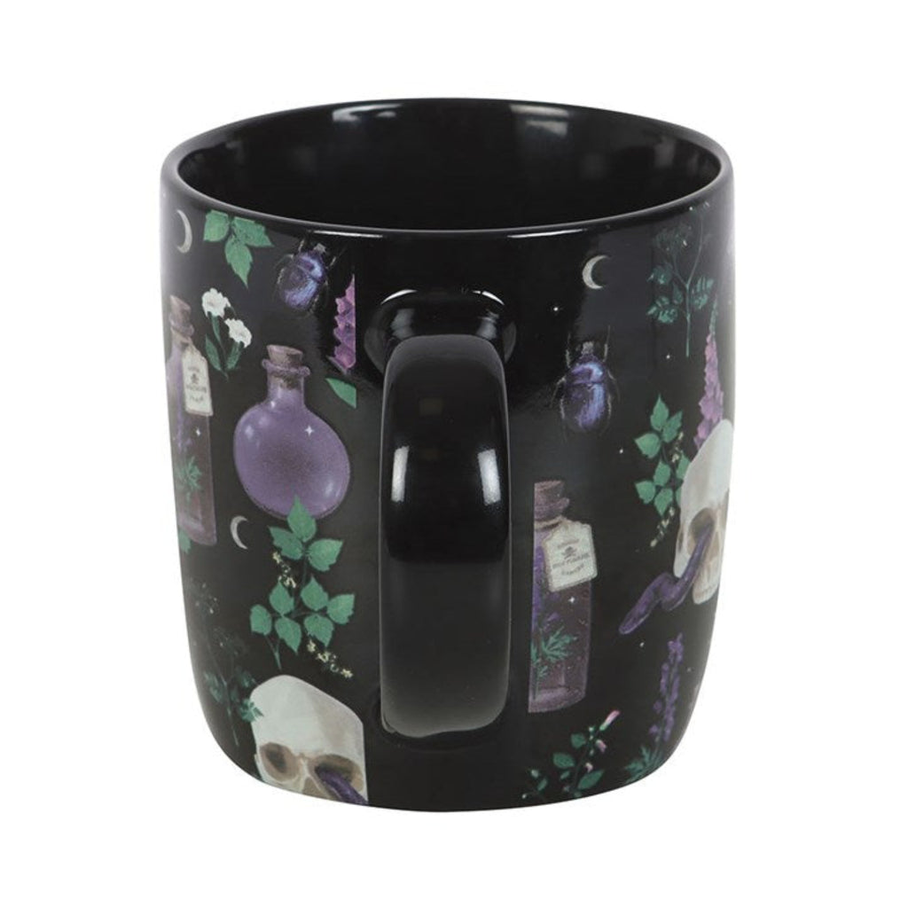 Black mug with mystical design featuring bottles, skulls, and plants on a white background
