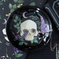 Decorative tray with skull and floral design on a dark background