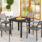 Black square outdoor dining table in a patio dining setting with slatted top