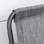 Close-up of curved armrest and grey mesh back on folding chair