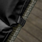 Black cushion corner with stitched tie loops attached to wicker surface