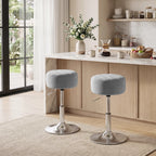 Two grey round swivel bar stools with chrome bases and footrest for bar-height seating