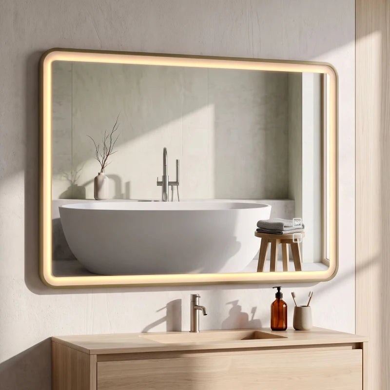 Gold-tone rectangle bathroom mirror with warm LED glow above a white sink and faucet.