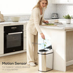 Silver stainless steel touchless sensor trash bin with open lid near kitchen counter