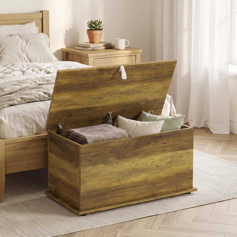 Brown blanket box with hinged lid open, interior storage compartment for linens and pillows.