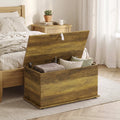 Brown blanket box with hinged lid open, interior storage compartment for linens and pillows.