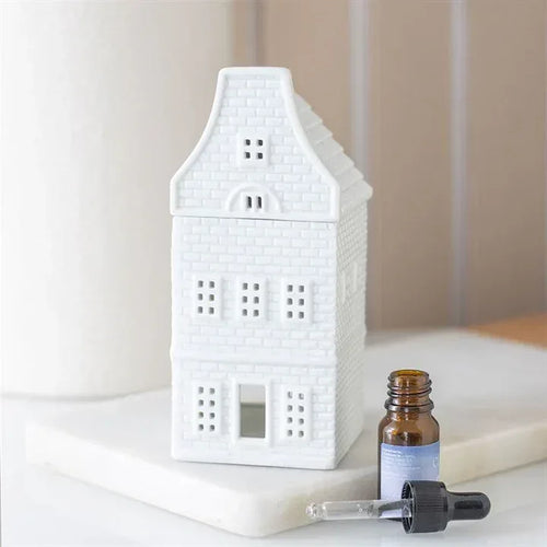 White house-shaped oil burner and wax warmer with chimney and window cutouts
