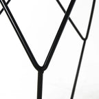 Black steel leg corner of a round side table with geometric frame