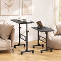 Set of black height-adjustable tables on caster wheels, each with lower shelf