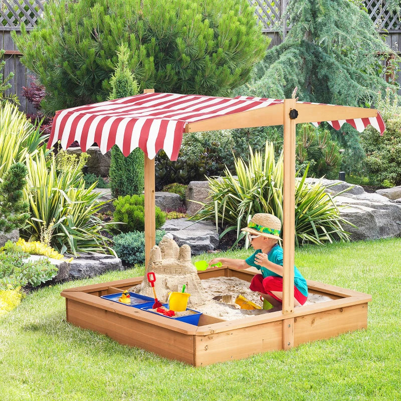 Wooden kids sandbox with red-and-white striped canopy in backyard, child playing in sand