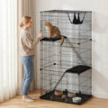Black 3-tier cat cage with hammock and lower tray, kitten relaxing inside