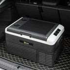 Grey and black portable car refrigerator in car trunk with front control panel