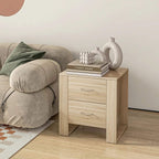 Wood side table with two drawers and curved metal handles next to an upholstered sofa