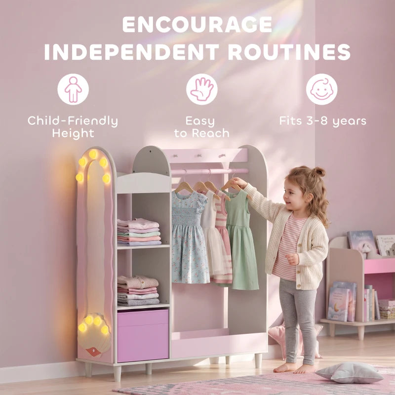 Pink kids clothing rack wardrobe with open storage, mirror, and glowing lights by the frame.
