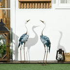 Pair of steel crane sculptures with white heads, blue feather scales, gold metal legs on stands