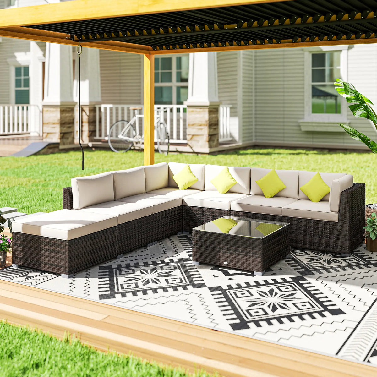 Brown rattan corner sofa set with cream cushions and glass-top table, arranged outdoors