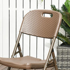 Dark brown rattan-style folding dining chair with woven back and curved armrests