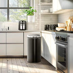 Stainless steel electric kettle on the floor in a modern kitchen near an oven